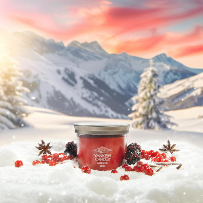 Apres Ski Collection Santa on Skis Signature Small Tumbler Candle in snow surrounded by berries, spices, and mountains