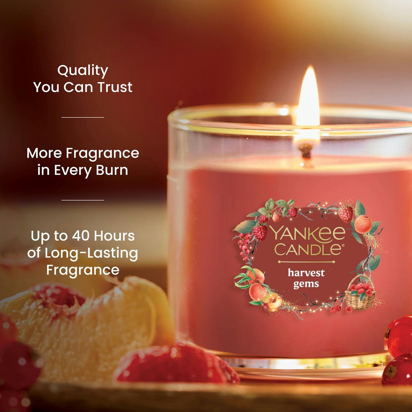 Red glass jar candle with fruit accents, promises up to 40 hours of long-lasting, quality fragrance burn time
