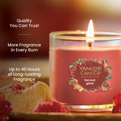 Red glass jar candle with fruit accents, promises up to 40 hours of long-lasting, quality fragrance burn time