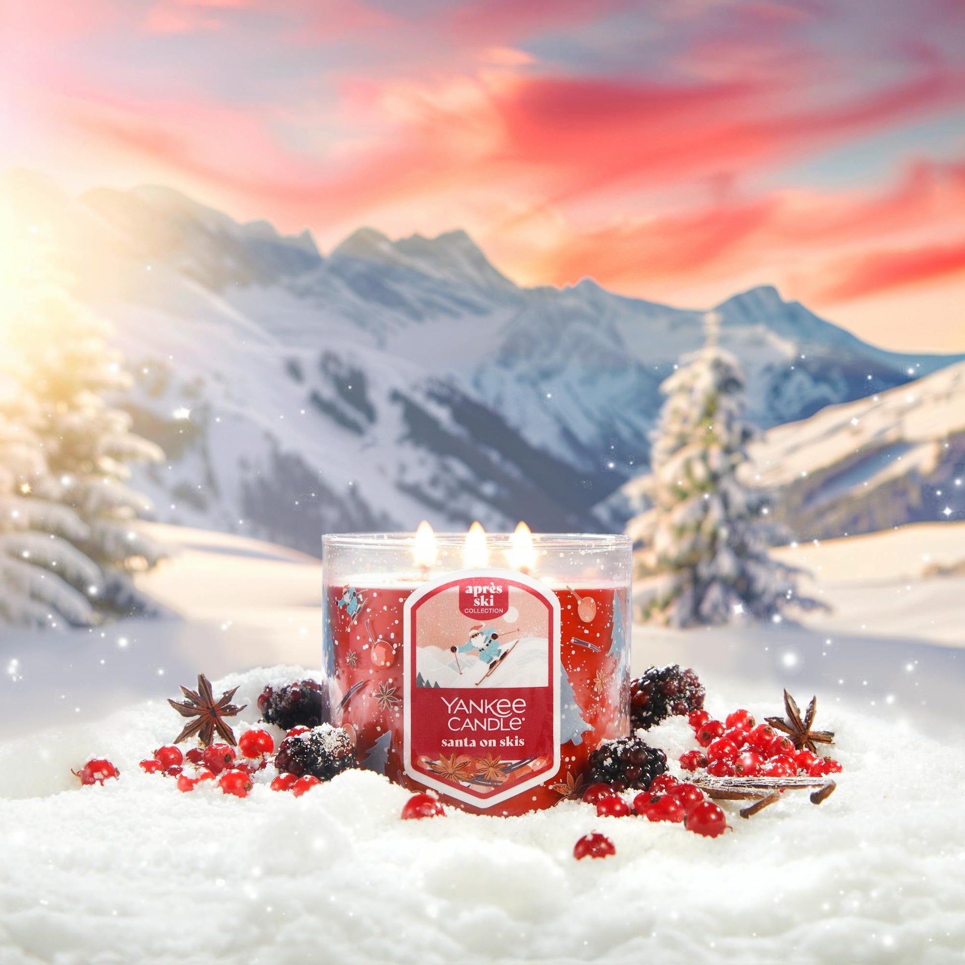 Apres Ski Collection Santa on Skis 3-Wick Candle in snow surrounded by berries, spices, and mountains